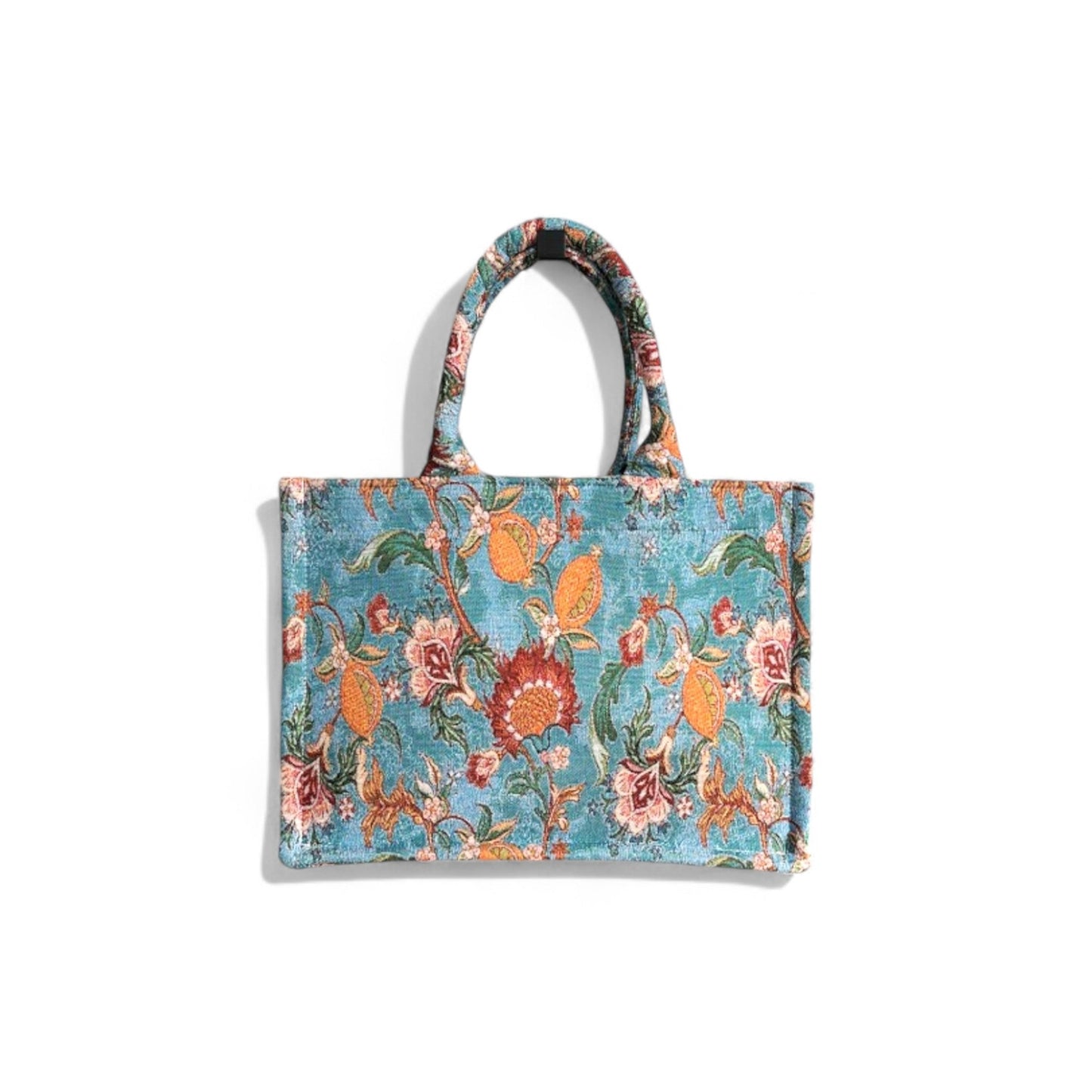 The textured surface of the blue vintage floral tote bag is shown in its front view details.