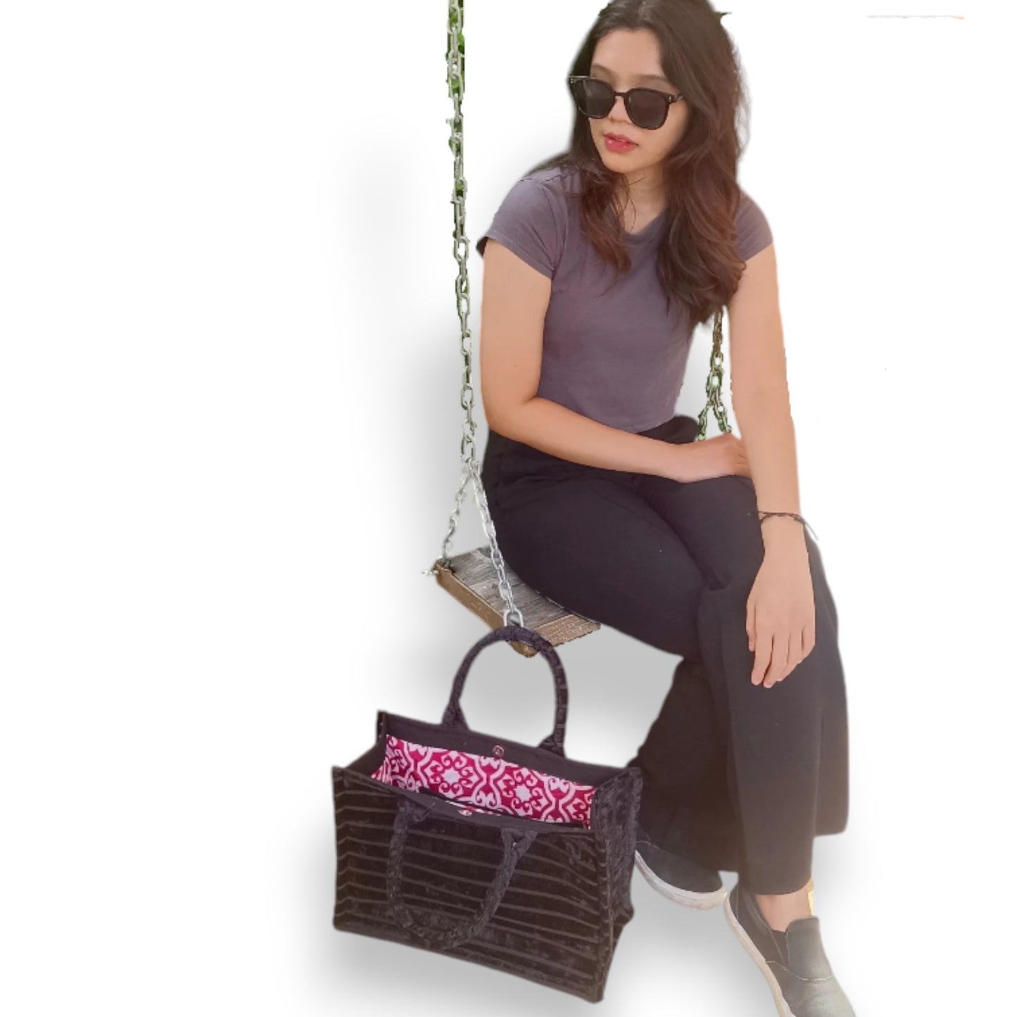Woman sitting on swing with Book Tote Black Chenille handbag, modern and elegant everyday fashion bag.