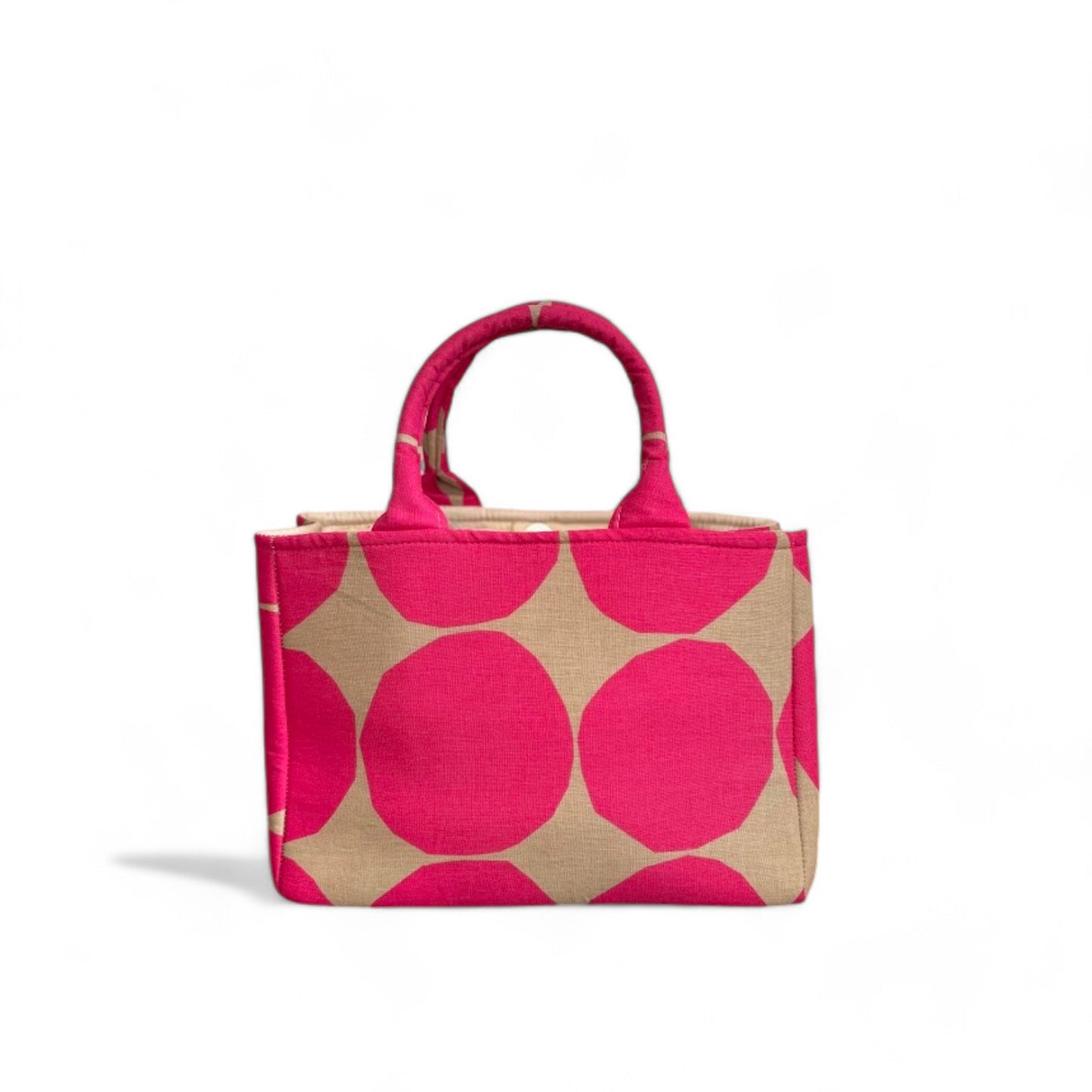 A front view of a handmade fabric mini tote with hot pink polka dots on a tan background.