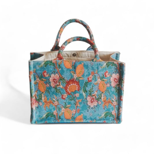 The blue vintage floral tote with double handles and sturdy structure, viewed from a high angle.