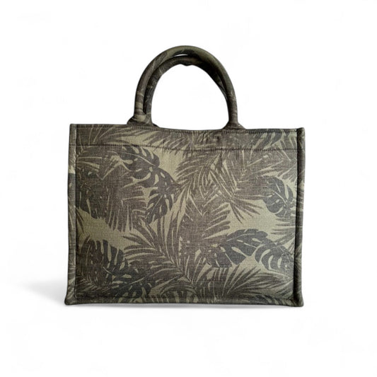 A book tote featuring black and green monstera and palm leaf patterns in the front view.