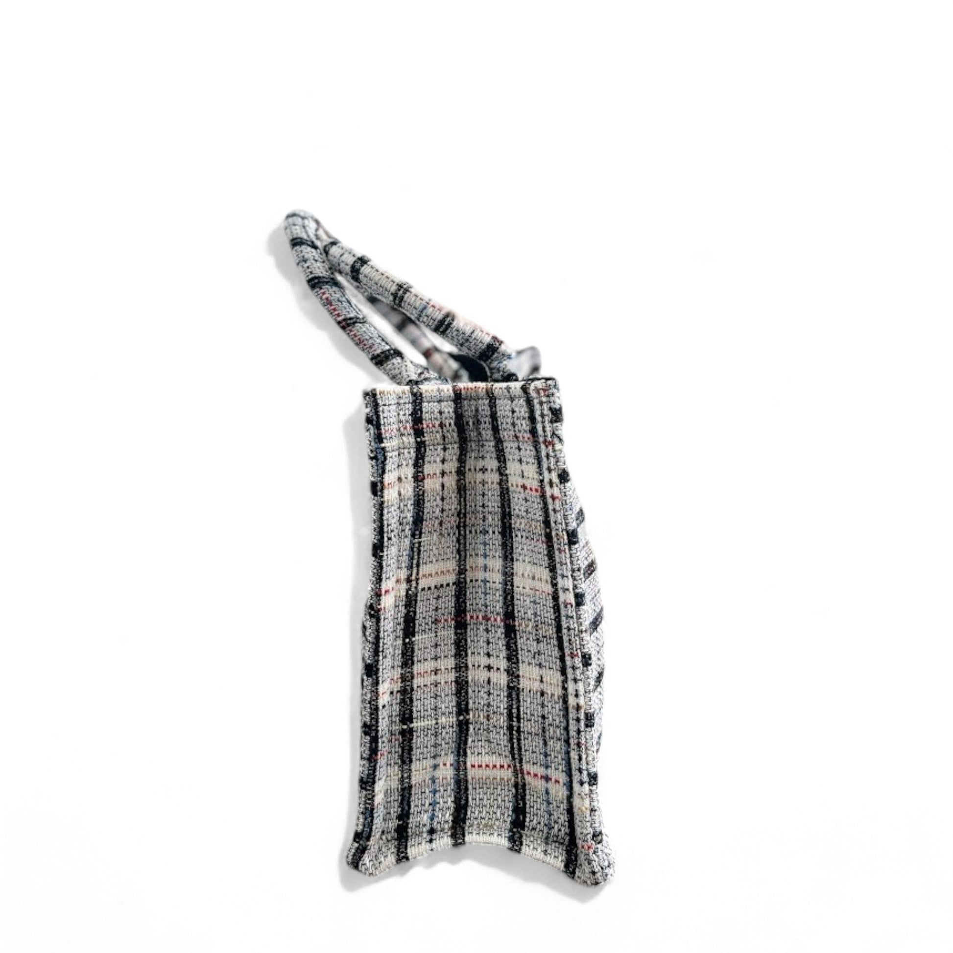 Side view of a classic plaid-patterned white tweed book tote bag.