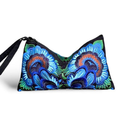 Front view of an intricate blue flower embroidered wristlet clutch bag with strap, handmade artisan design.