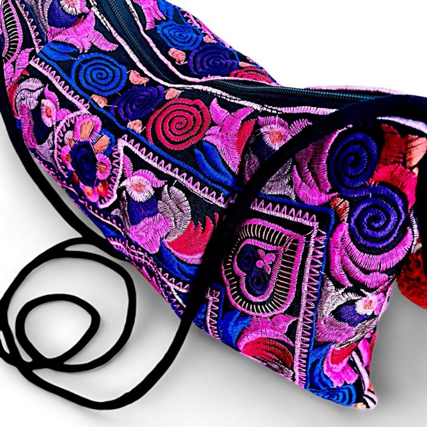 A close-up of a pink multi colour embroidered bag with intricate floral and bird patterns.