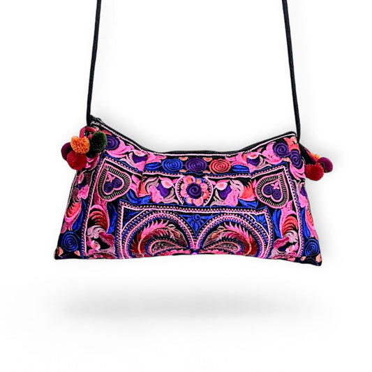A pink multi-colour embroidered bag with colourful mini pompom charms.