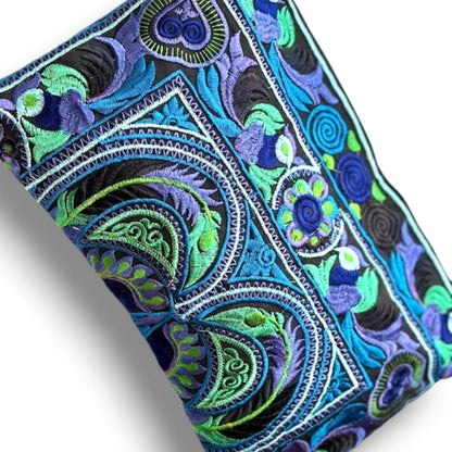 Close-up of Hmong embroidered bag in sky blue and green with unique bird & floral patterns.