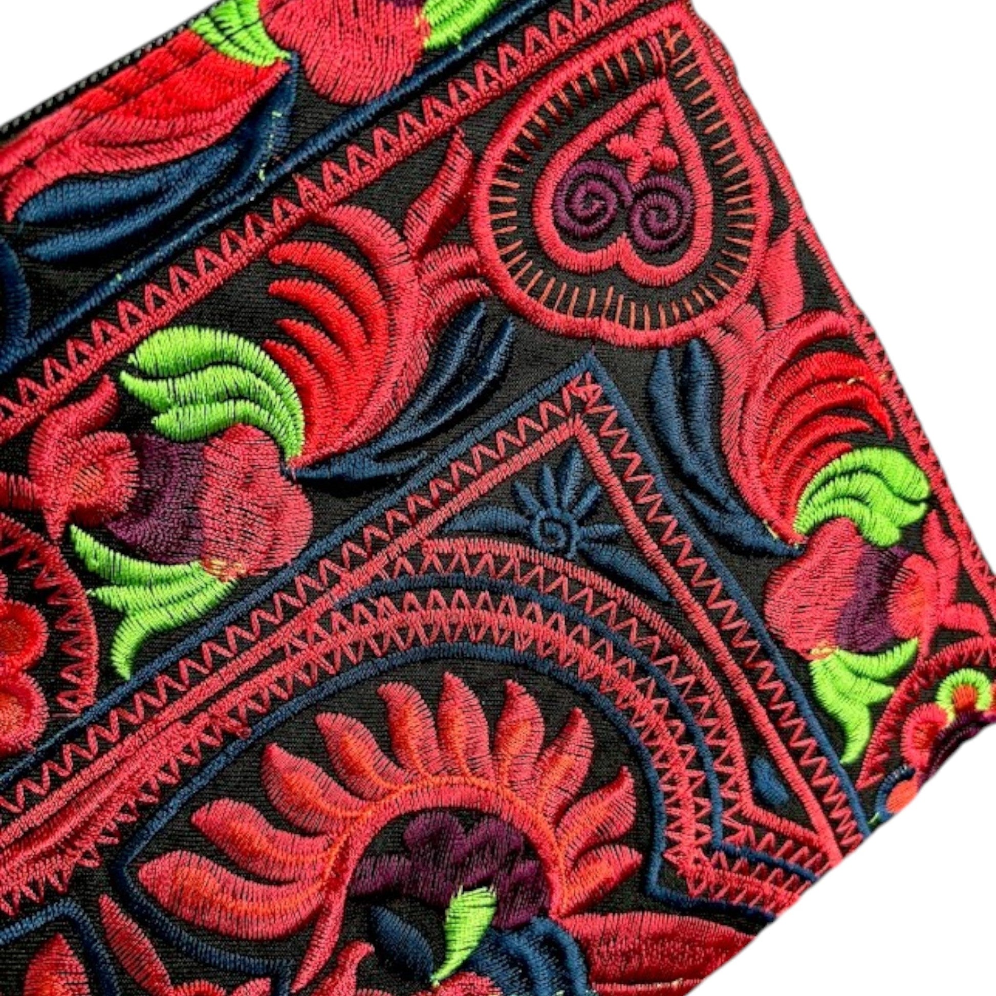 Close-up of Hmong wristlet bag showing intricate bird embroidery in red, blue, and bright green.