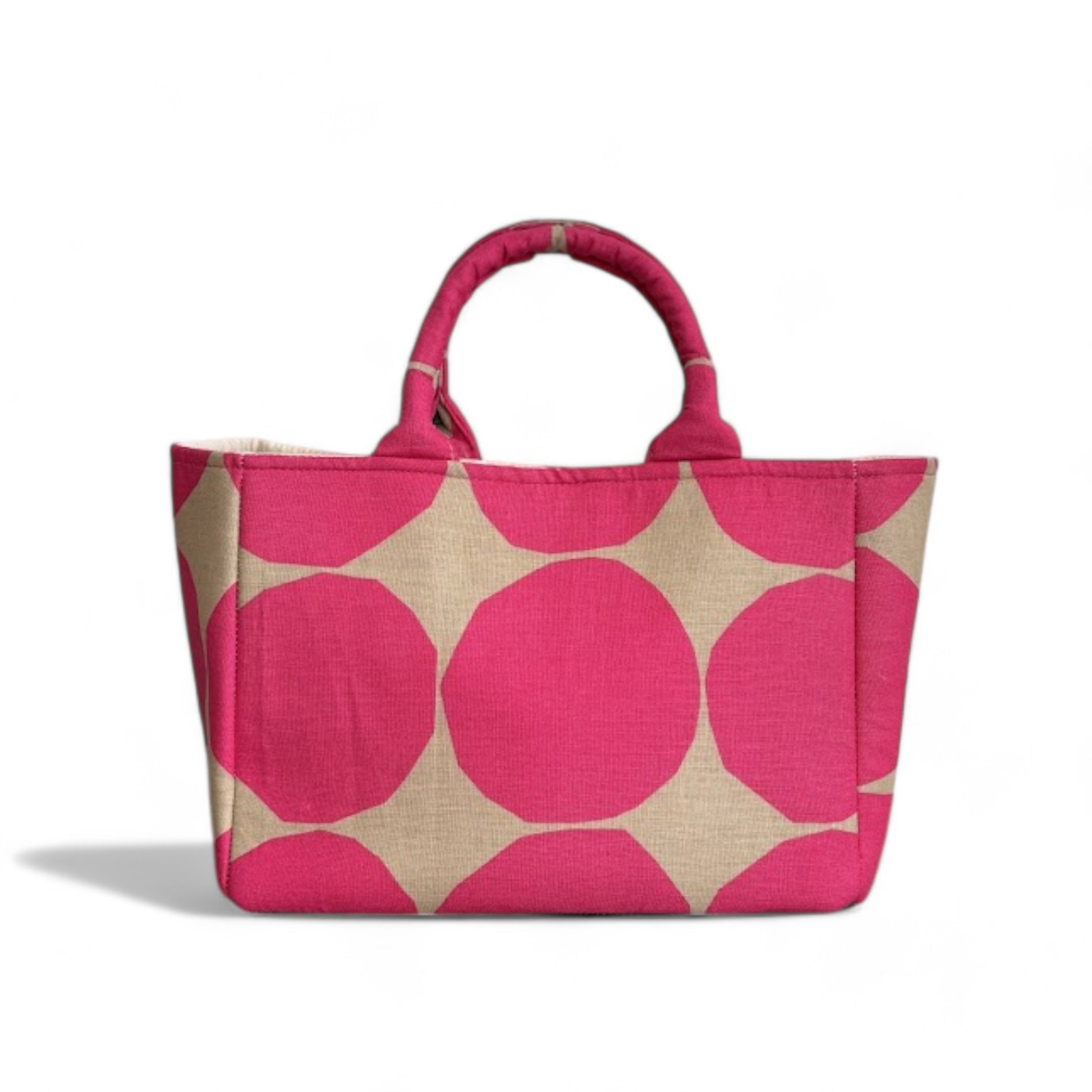 A handmade hot pink and tan dots tote bag with expanded side panels.