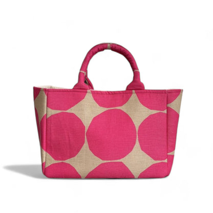 A handmade hot pink and tan dots tote bag with expanded side panels.