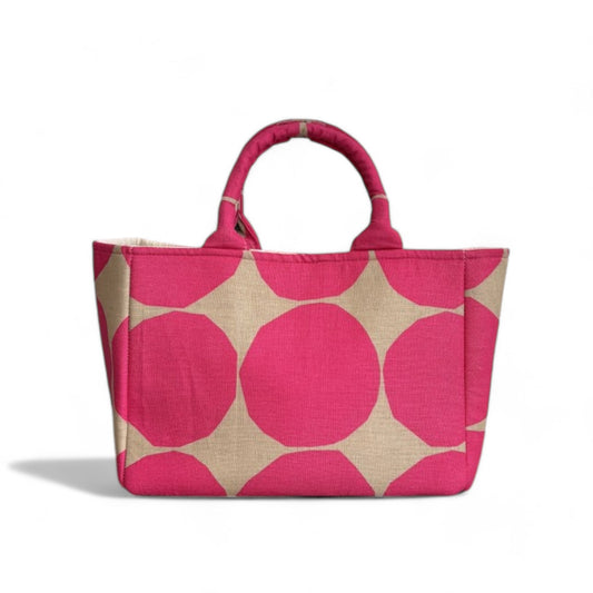 A handmade hot pink and tan dots tote bag with expanded side panels.