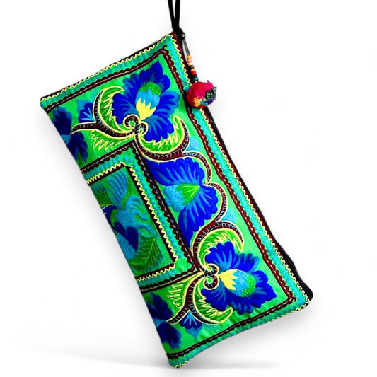A rectangular pouch with bright green and blue peacock and floral patterns.