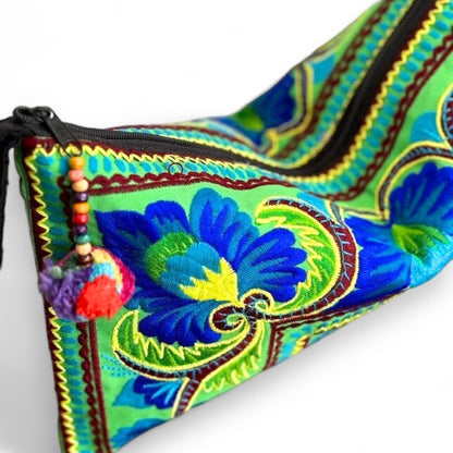 Front view of a rectangular bag featuring green and blue peacock and floral patterns with mini pompom.