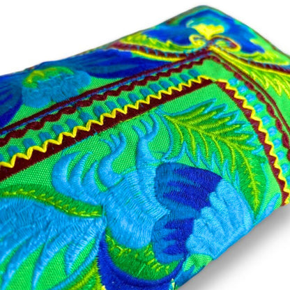 Close-up of a wristlet clutch showing intricate Hmong embroidery with vibrant blue and green.