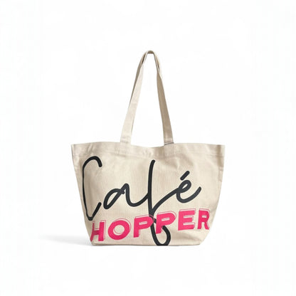 Oversized Café Hopper tote with long handles and modern lettering design for everyday carry.