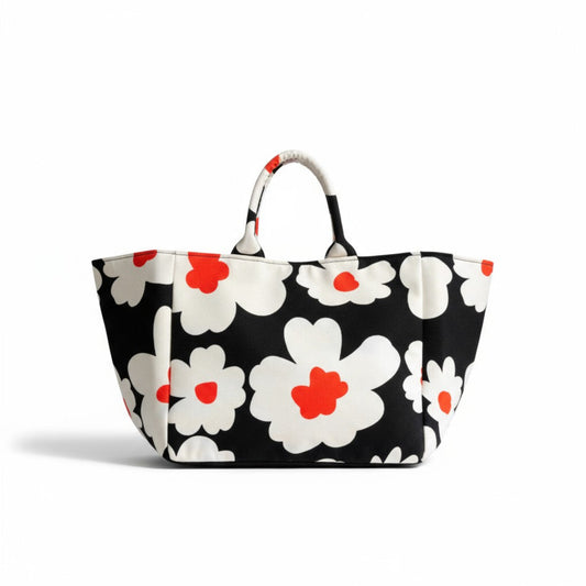 The Flower Bomb handmade shopper tote has a black background with large white and orange flower prints.