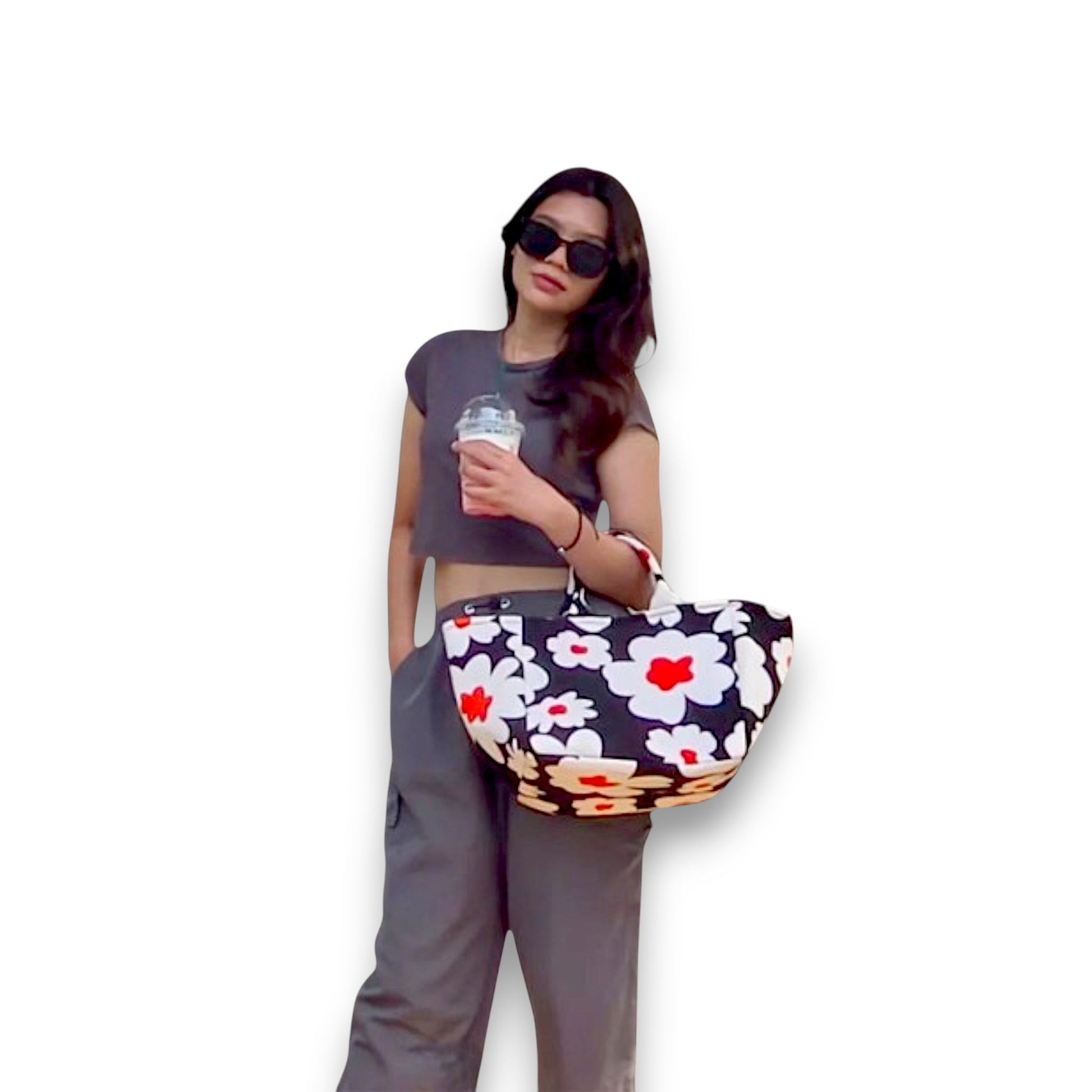 Model holding a large Flower Bomb shopper tote, a black bag with large white flowers, and an orange accent.