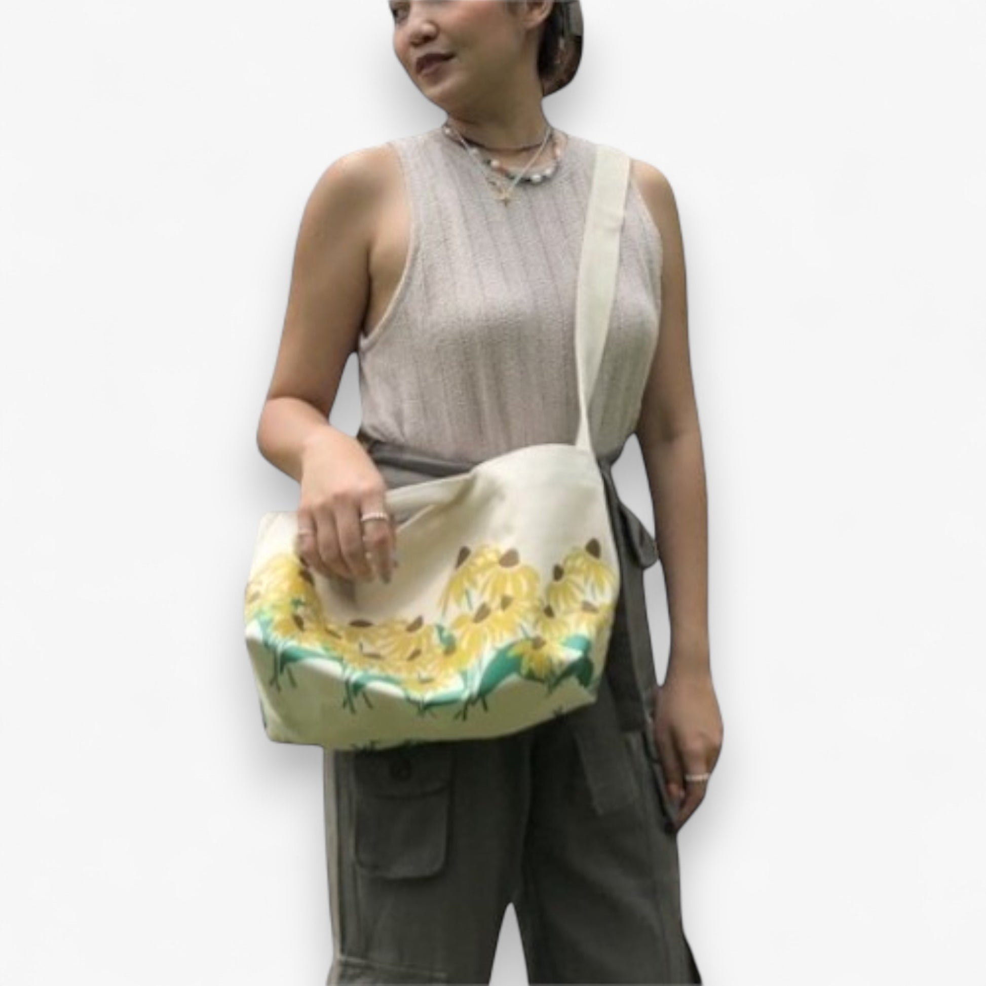 Model showcasing an eco-friendly sunflower canvas tote bag with a long strap and handles.