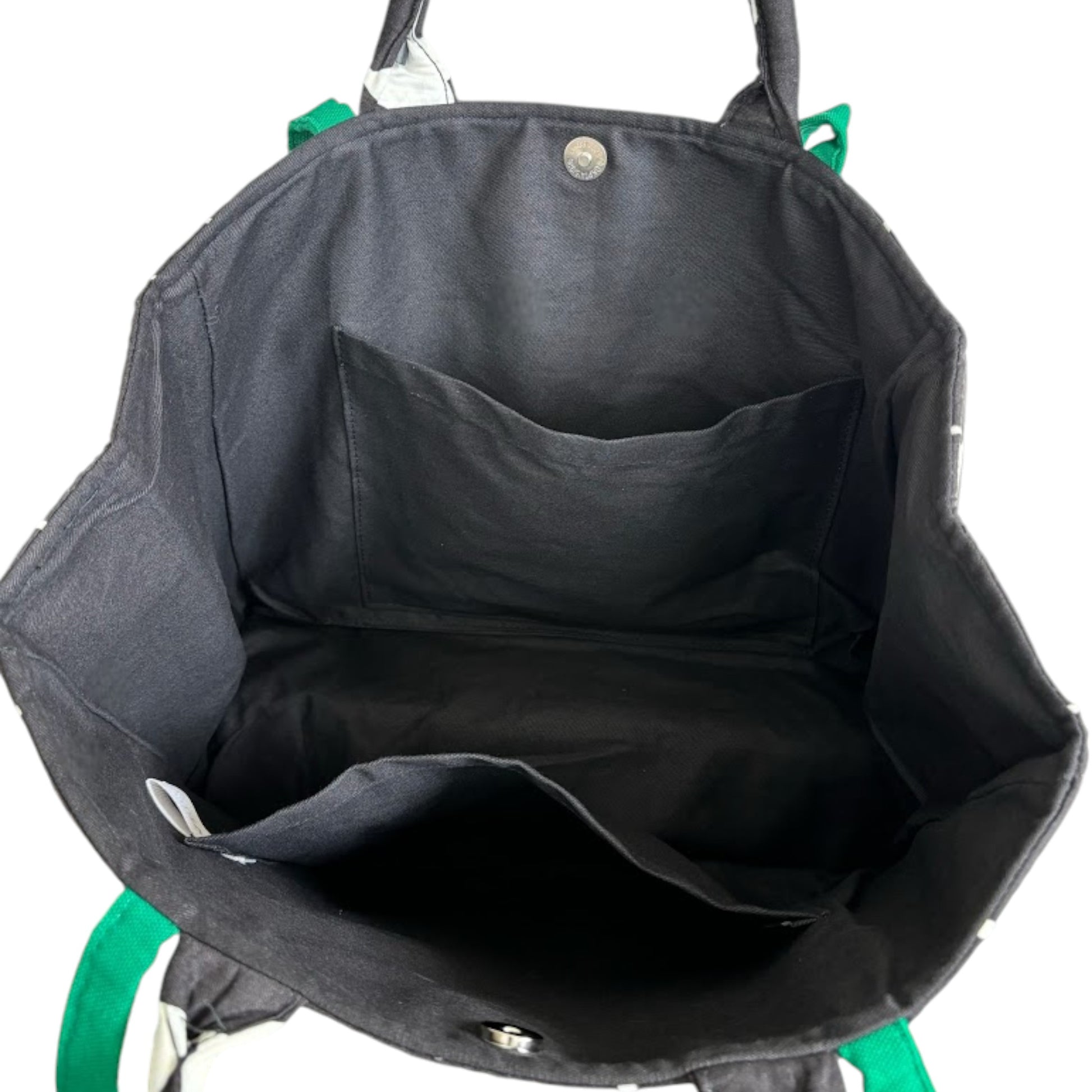 Looking inside a fabric shopper-bag with two slip pockets and black lining.